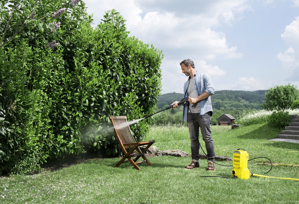 Ένας άντρας καθαρίζει τα έπιπλα του κήπου του.